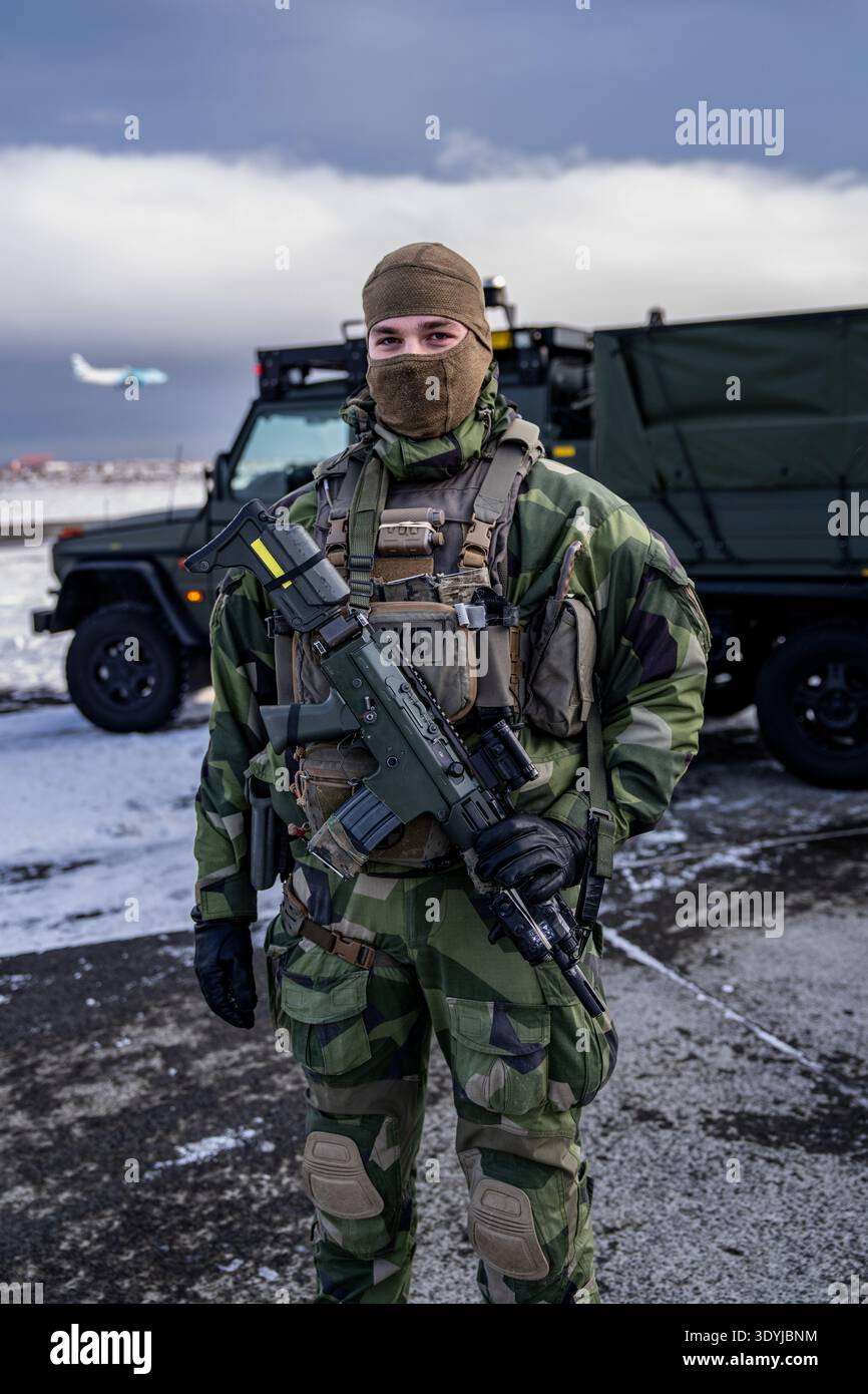 Un agente di sicurezza dell'Aeronautica svedese si trova fuori da un rifugio per aeromobili temprato presso la base aerea di Keflavik in Islanda, mentre era schierato come parte dell'Arcti della NATO Foto Stock