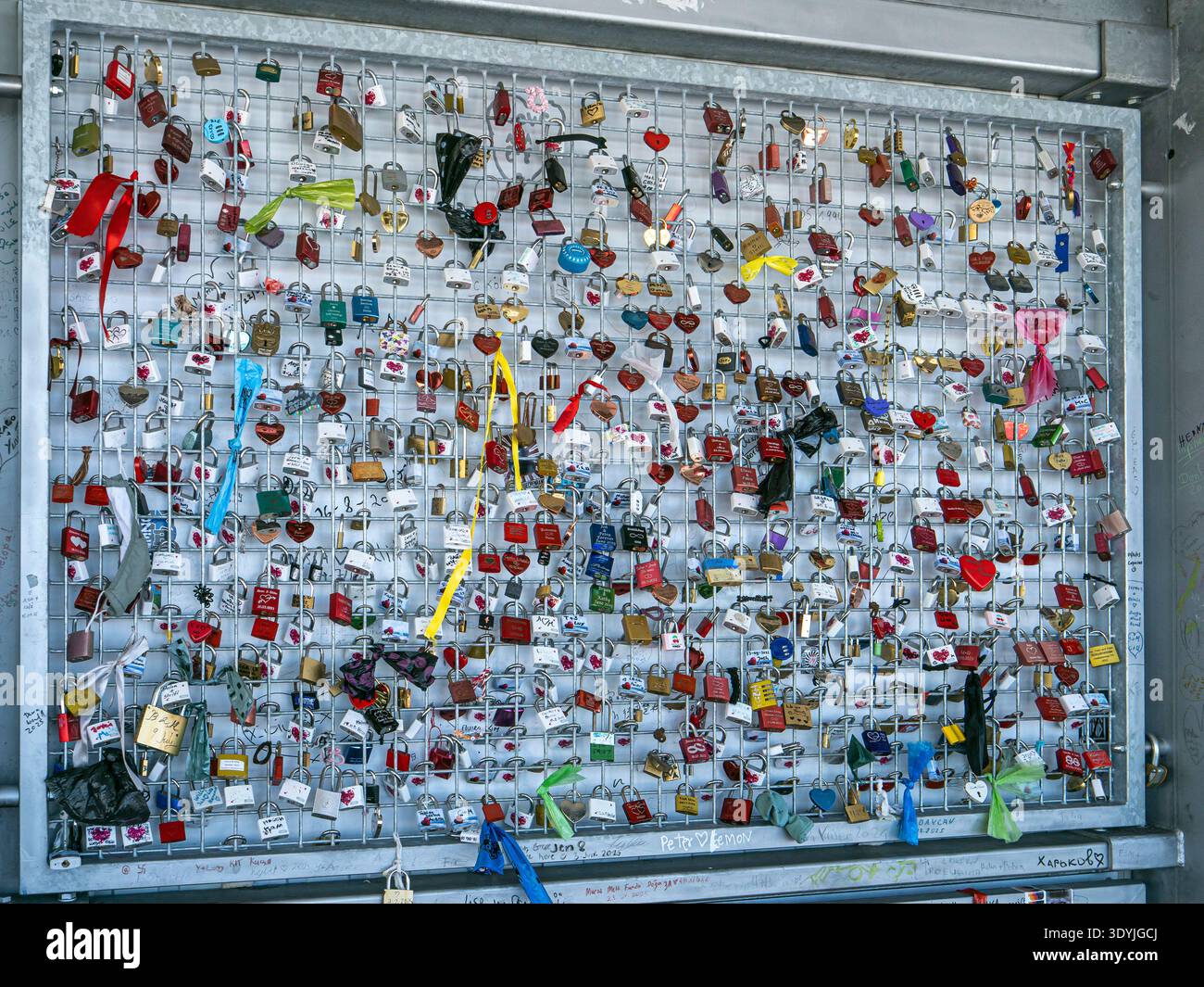 Primo piano di un muro di un ponte con lucchetto d'amore caratterizzato da centinaia di lucchetti colorati con nomi e nastri in Tirolo, Austria Foto Stock