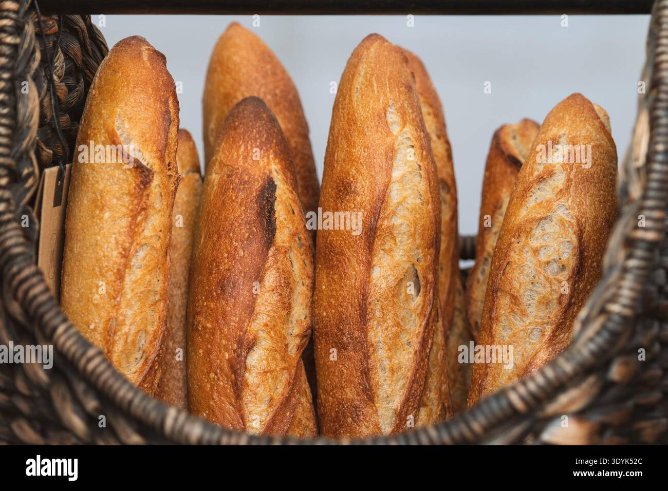 Baguette appena sfornate esposte in cesti di vimini presso una panetteria o un mercato di Street food Foto Stock