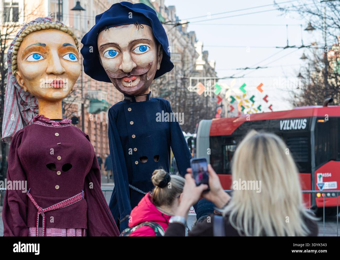 Figure giganti che rappresentano una coppia con abiti tradizionali lituani trasportati per le strade di un tradizionale teatro di San Casimiro Foto Stock
