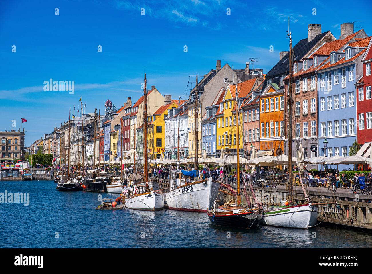 Porto di Nyhavn con case storiche colorate e barche tradizionali lungo il canale sul lungomare di Copenaghen, Danimarca Foto Stock