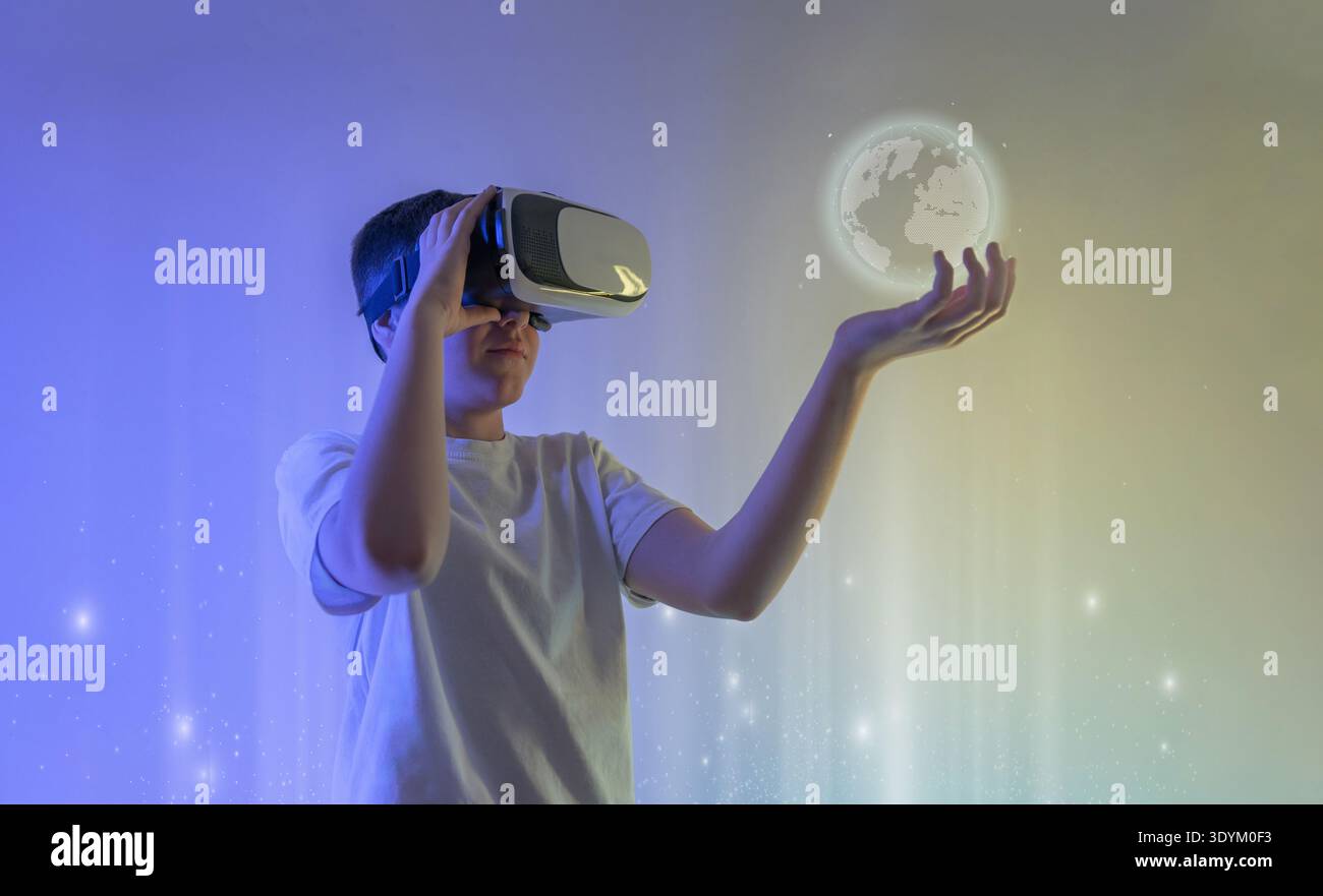 Ragazzo che indossa un visore per la realtà virtuale che interagisce con un globo digitale olografico che rappresenta la comunicazione globale, la tecnologia metaversa e l'immersivo Foto Stock