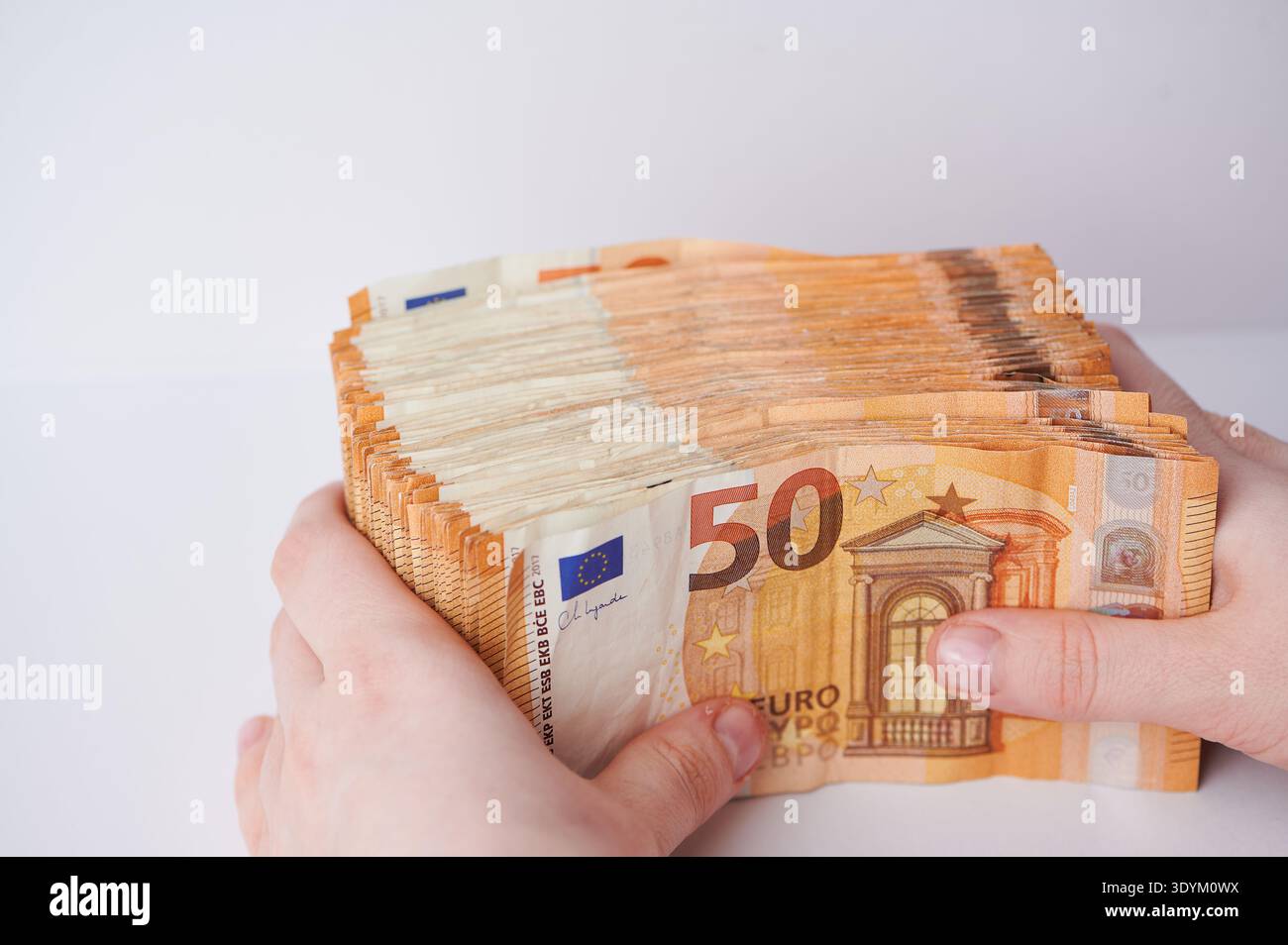 Grande pila di banconote da 50 euro in mano su sfondo bianco Foto Stock