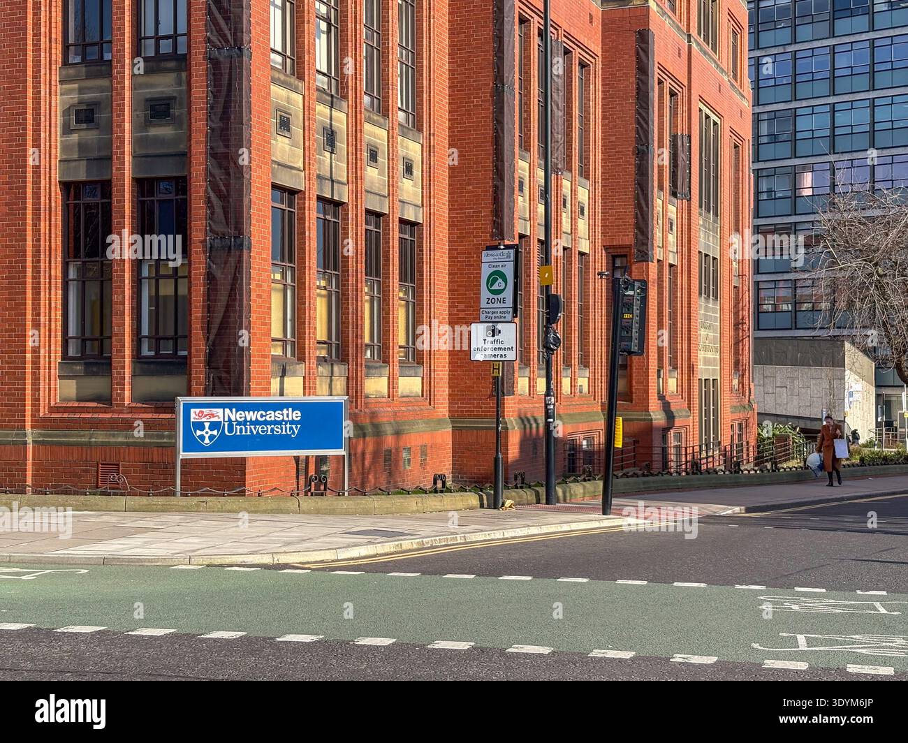 Newcastle, Regno Unito. 4 marzo 2026. Una persona passa davanti a un cartello per la Newcastle University in una giornata di sole. Foto Stock