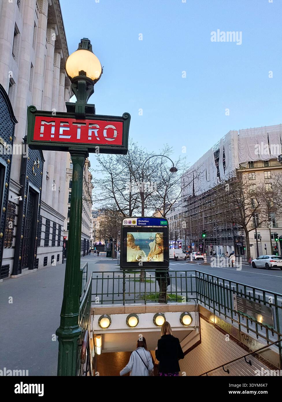 Cartello d'ingresso della metropolitana di Parigi alla stazione Richelieu-Drouot con architettura Haussmann a Parigi in Francia Foto Stock