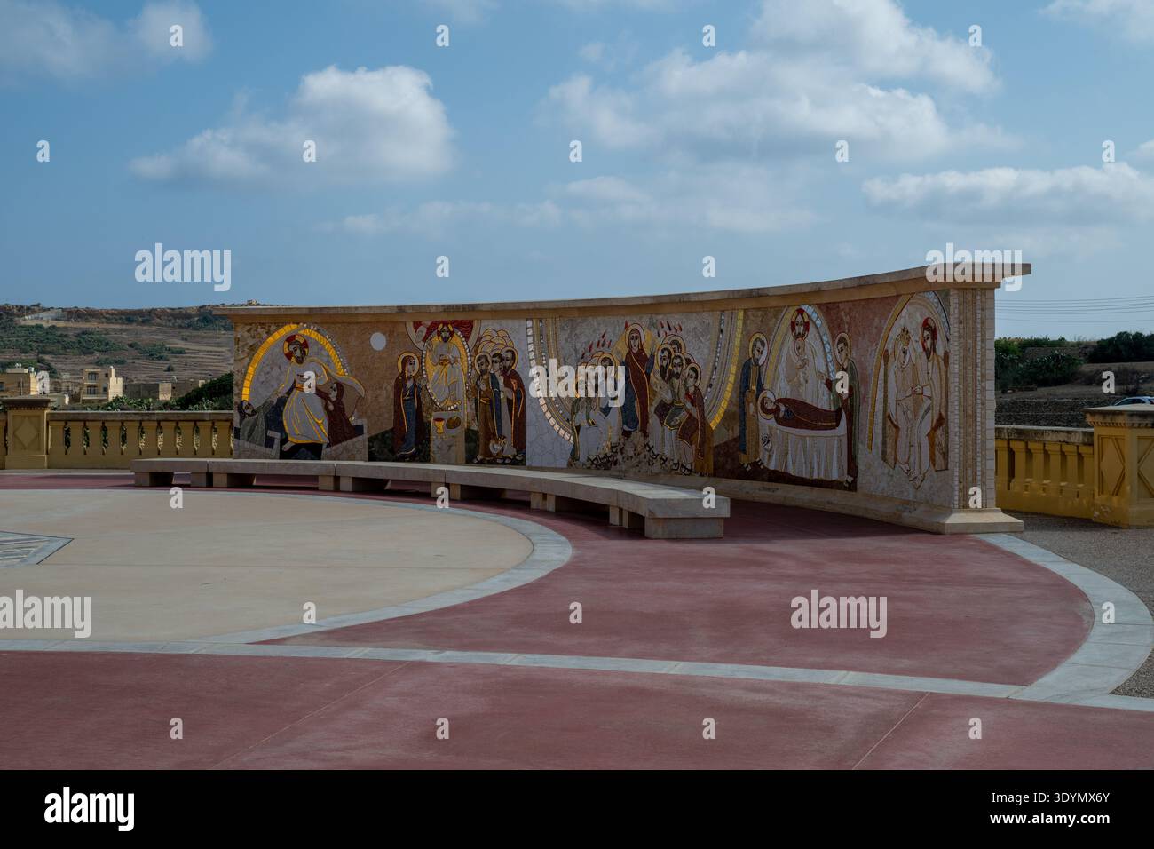 Terrazza curva con murale a mosaico di santi e la Vergine Maria al santuario della basilica di Ta Pinu a Gharb, Gozo, Malta, sotto un cielo blu. Foto Stock
