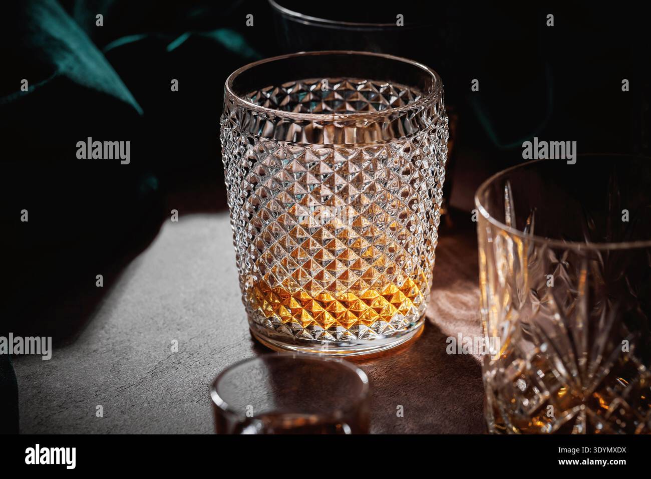 Bicchiere di whiskey su tavolo da bar in legno con luce drammatica Foto Stock