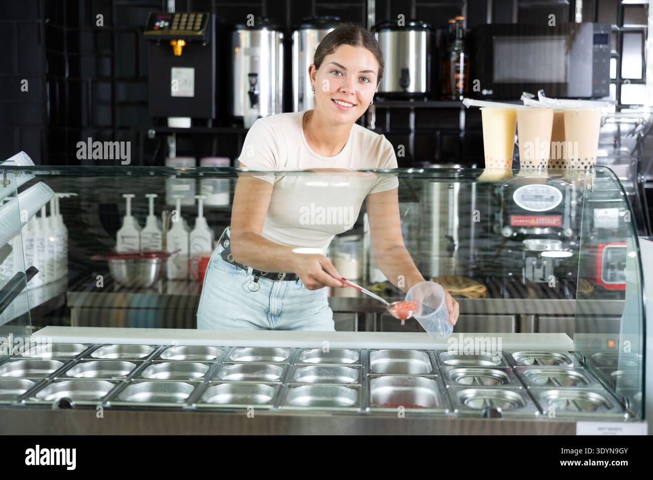 Una giovane donna che mette le palle di succo per il tè bollente Foto Stock