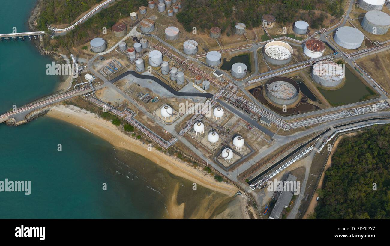 Vista aerea di un vasto paesaggio industriale dove le vasche metalliche brillano sotto il sole sullo sfondo del mare, Thung Sukhla, Chon Buri, Tha Foto Stock