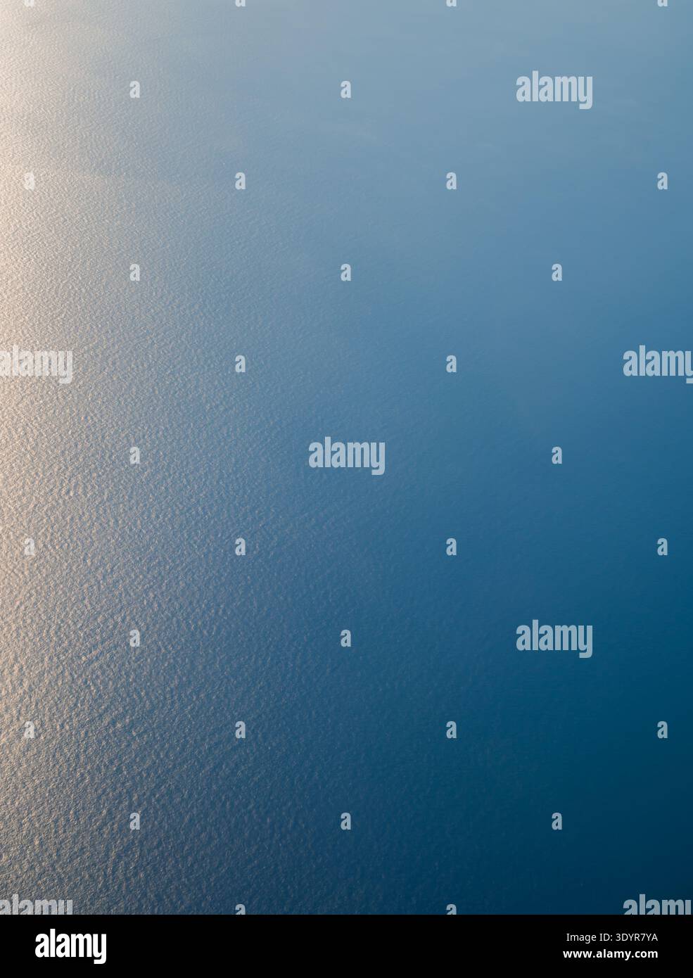 Guardando in basso sul vasto oceano blu dalla finestra dell'aereo. Foto Stock