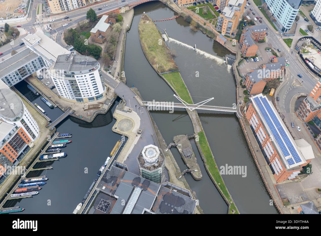 Vista aerea del molo di Leeds e del fiume Aire, con ponte pedonale, moderni appartamenti, barche e quartiere sul lungomare Royal Armouries a Leeds Foto Stock