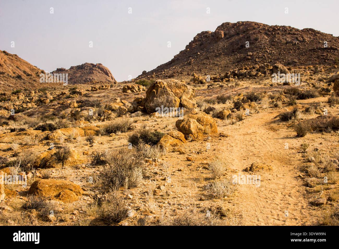 Sentiero che si addentra nell'ambiente arido e roccioso tra le colline granitiche di Aus Foto Stock