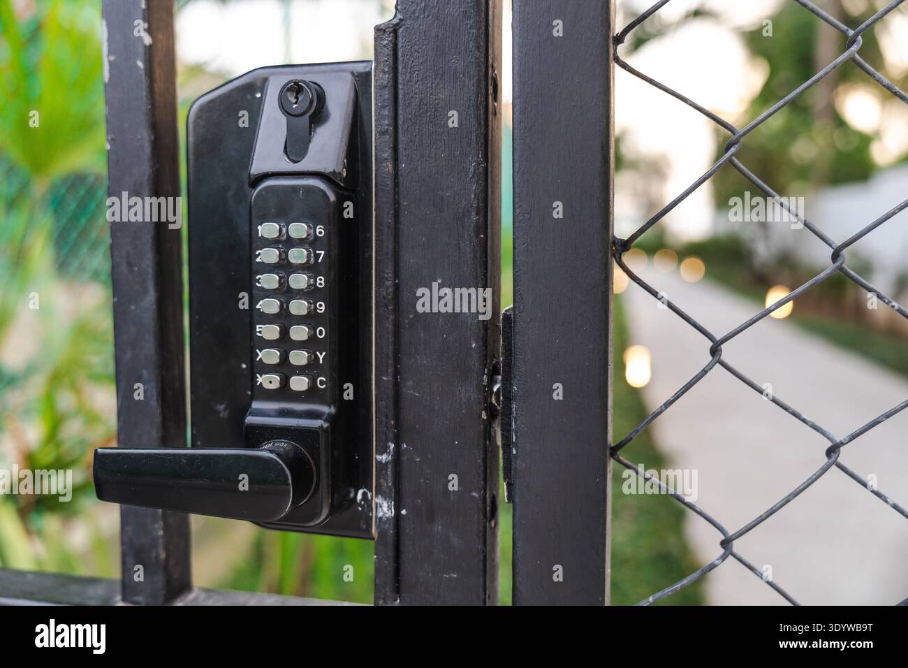 Serratura elettronica con tastiera su cancello metallico per un controllo sicuro dell'accesso alla proprietà privata Foto Stock