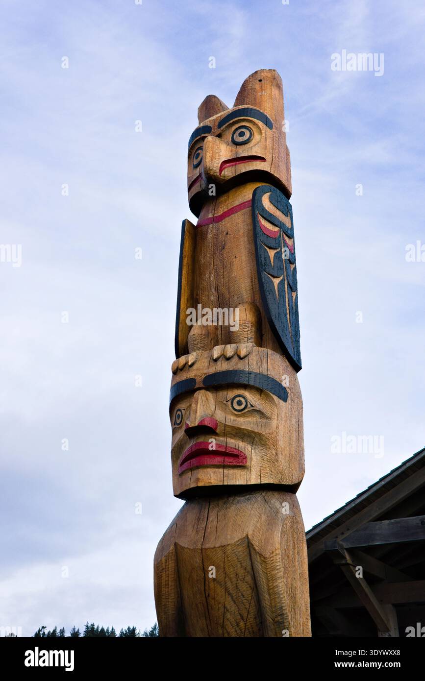 Dettaglio di un palo totem indigeno in legno intagliato contro un cielo blu morbido nel Marina Park, Comox, Isola di Vancouver, British Columbia, Canada. Foto Stock