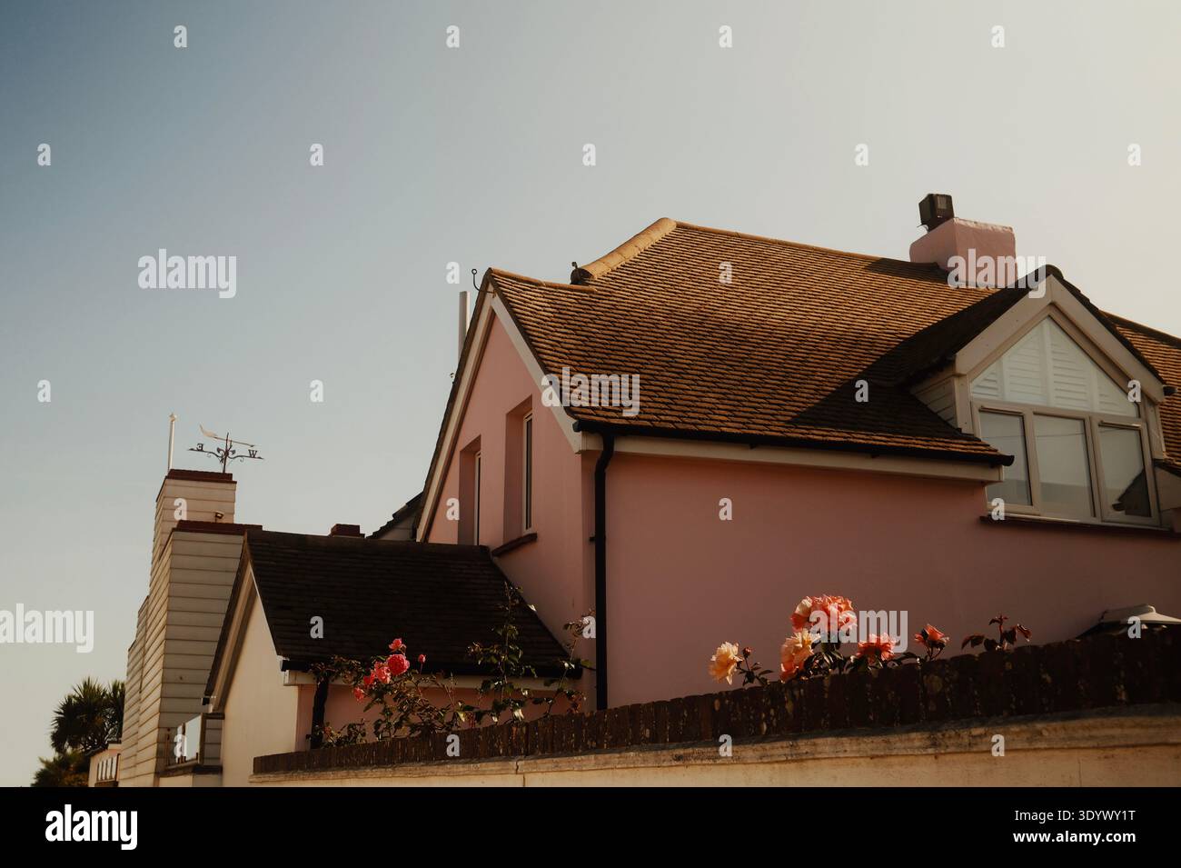Casa sul mare rosa con tetto a spiovente e fiori in una strada residenziale nella città costiera britannica di Worthing, West Sussex, Inghilterra, Regno Unito Foto Stock