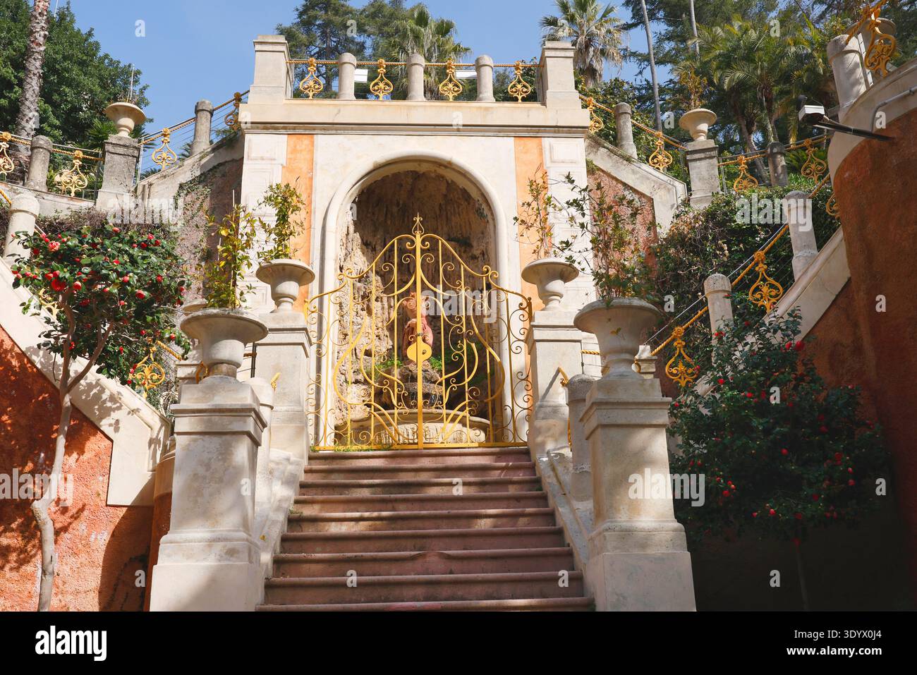 Elegante scalinata classica in pietra con porte dorate ornate nel Parco di Villa Rocca. Una maestosa scalinata in marmo caratterizzata da balaustre decorative Foto Stock