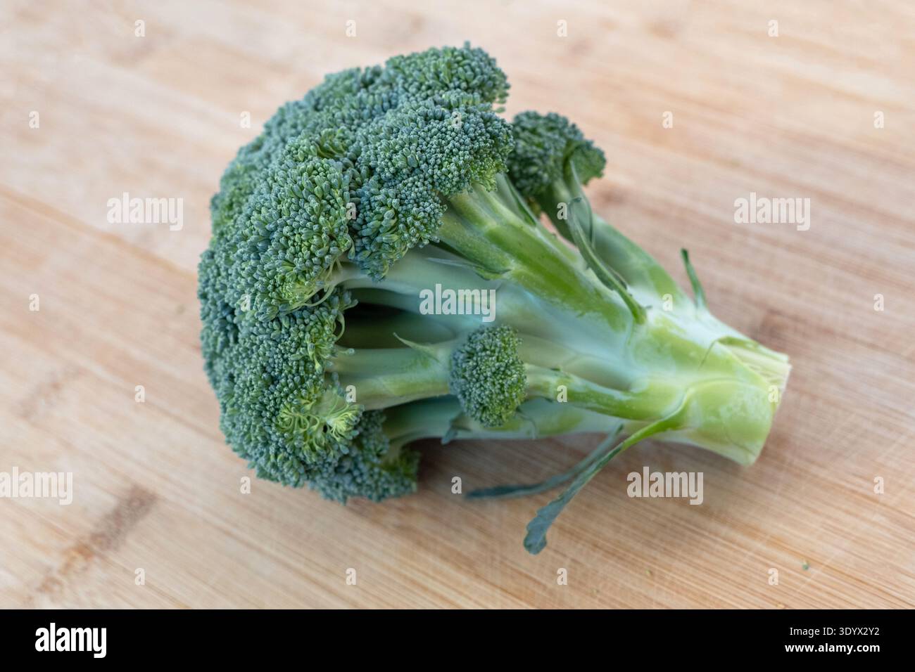 Broccoli verdi freschi su tagliere in legno. Ingrediente vegetale sano ricco di vitamine e fibre. Foto Stock