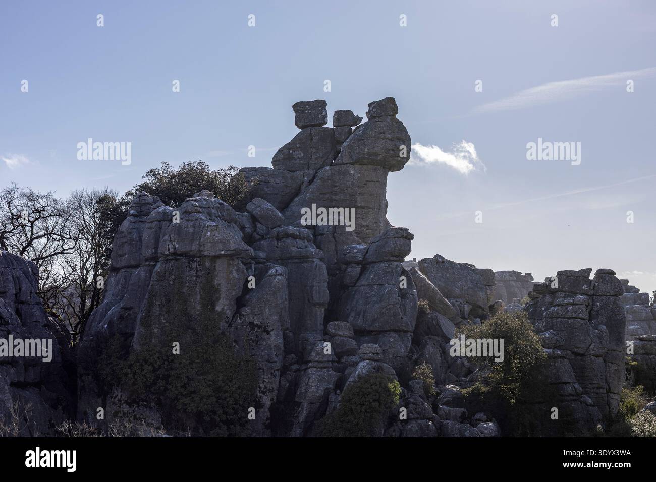 I visitatori camminano tra le grandi formazioni rocciose di El Torcal in Spagna. Il sole brilla e le nuvole si muovono lentamente nel cielo. L'area è conosciuta per la sua Foto Stock
