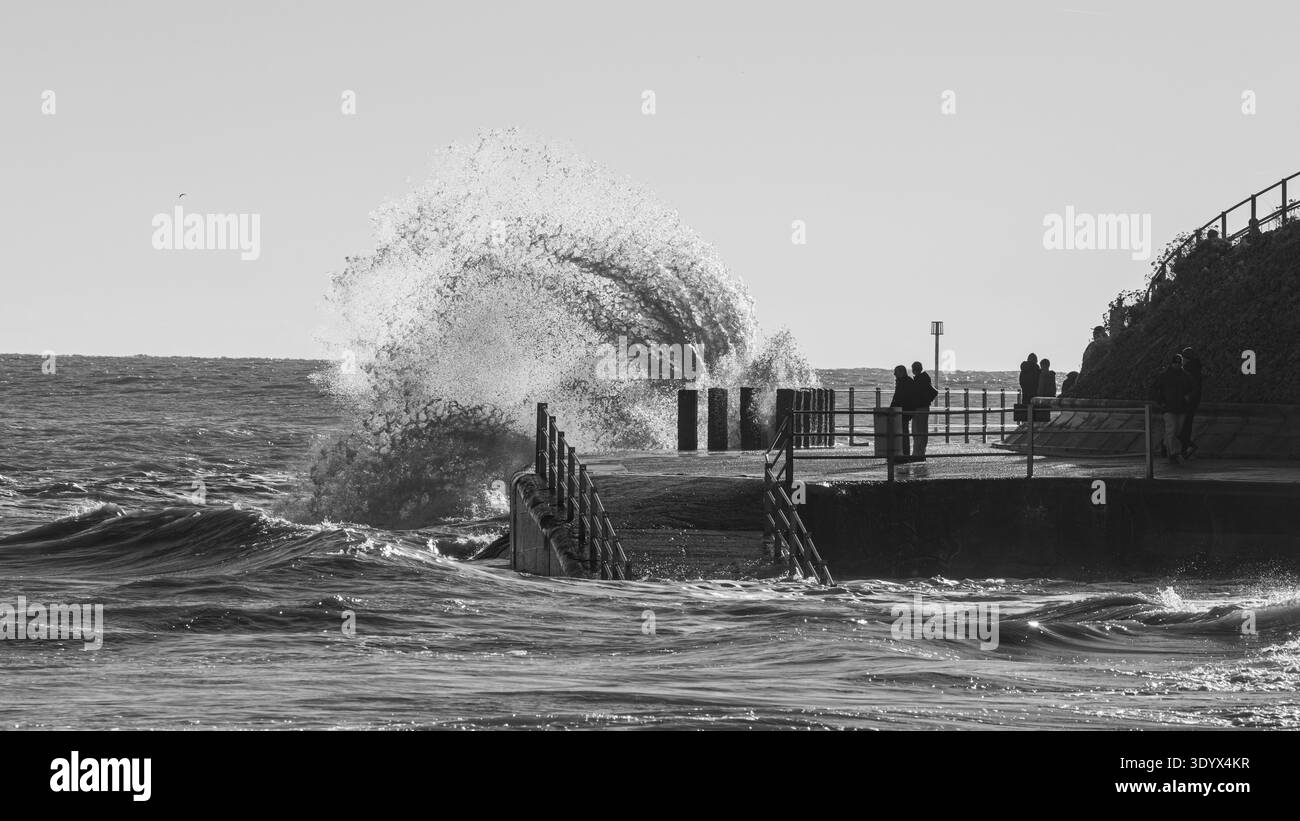 Alte maree con onde che si infrangono sul lungomare Foto Stock