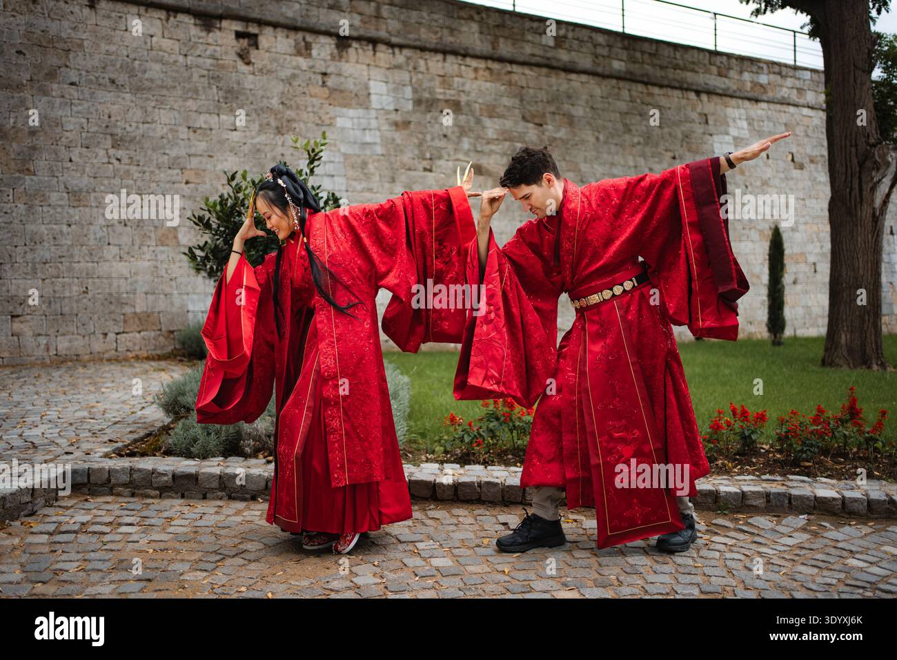 Coppia felice e variegata ballando giocosamente durante la cerimonia nuziale Foto Stock