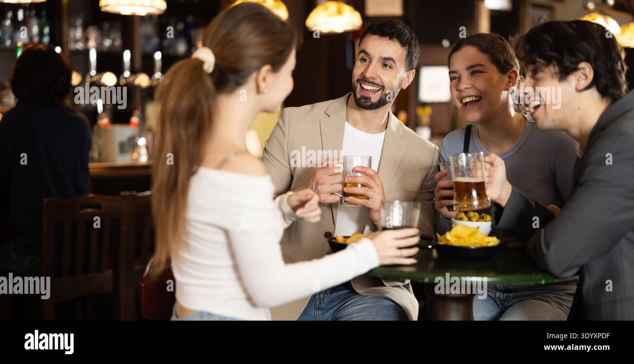Gruppo di giovani amici felici che si divertono insieme nel pub della birra Foto Stock