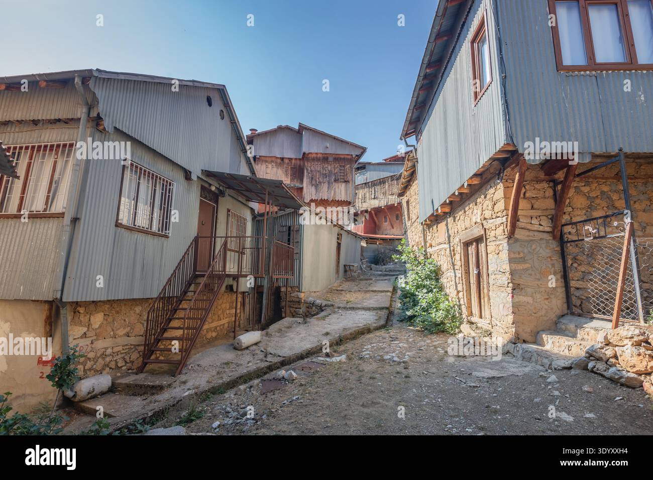 Tradizionale architettura vernacolare dei villaggi di Kemaliye con case in pietra e legno caratterizzate da facciate in metallo ondulato a Erzincan, Turchia Foto Stock