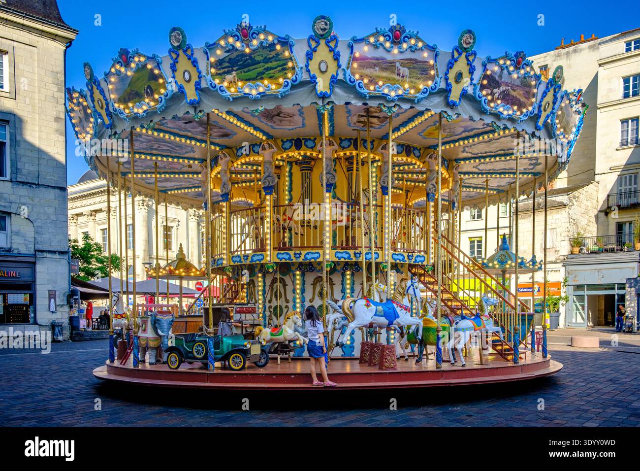 Giro in giostra tradizionale nella storica piazza della città con gli edifici circostanti, Saumur, Francia Foto Stock