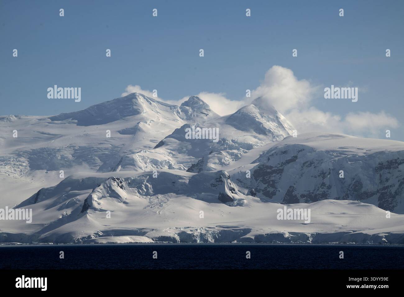 Vista delle alte montagne innevate avvolte da nuvole, della penisola Antartica e dell'Antartide Foto Stock