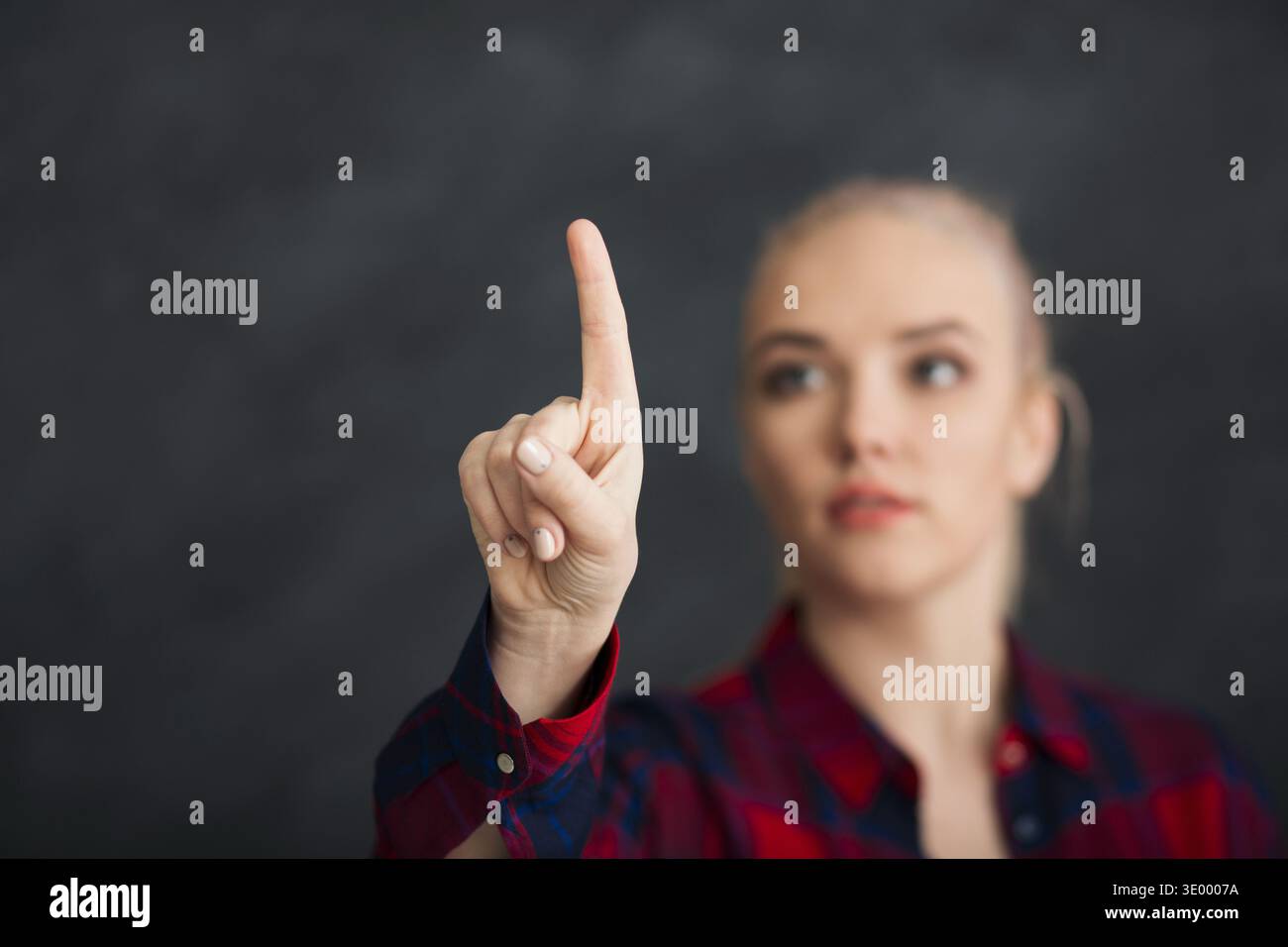 Donna seria che punta sullo schermo visivo Foto Stock