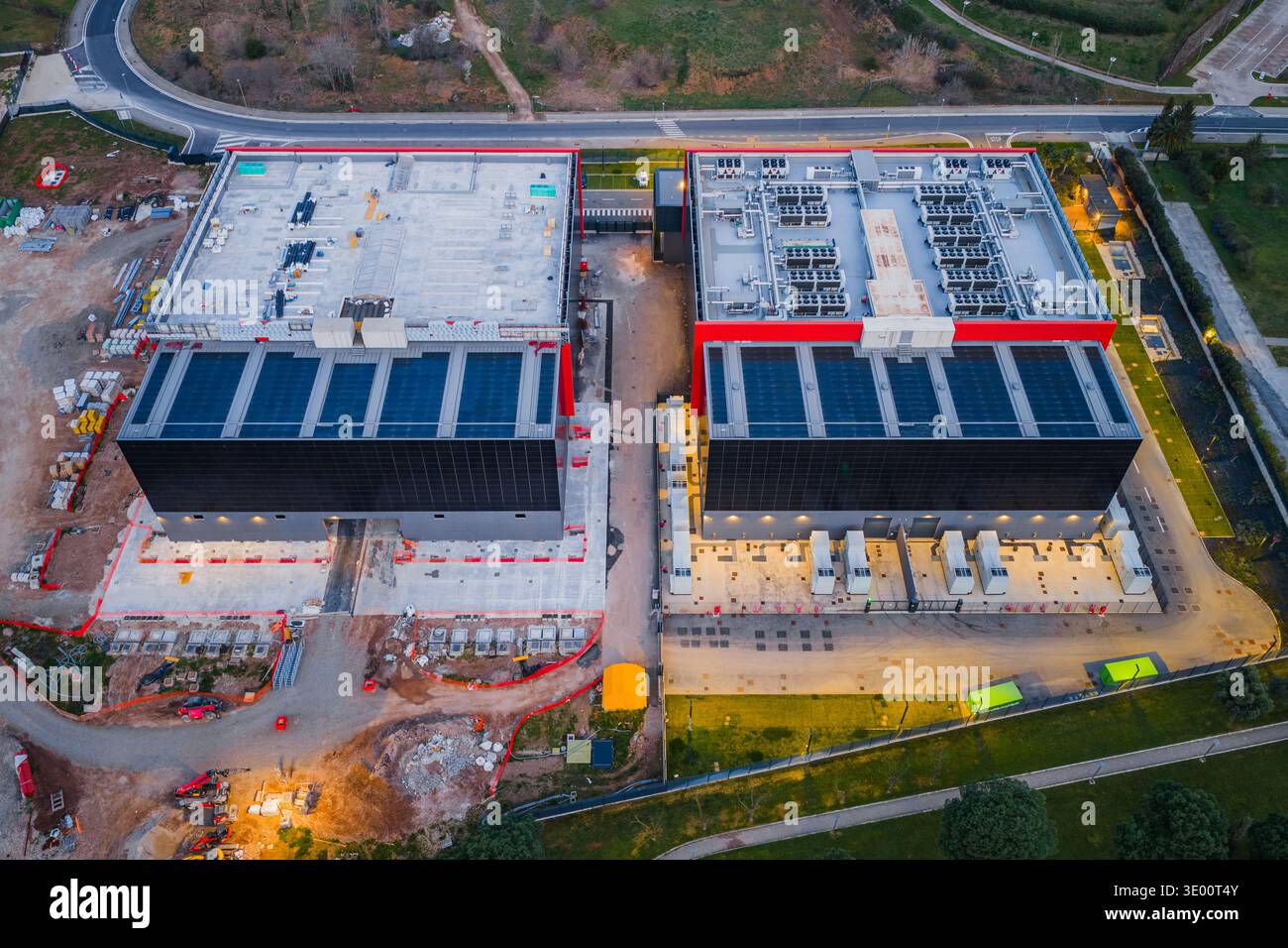 Vista aerea dell'imponente complesso di data center, le sue forme angolari nettamente definite rispetto al verde circostante, una moderna fortezza tecnologica, Foto Stock