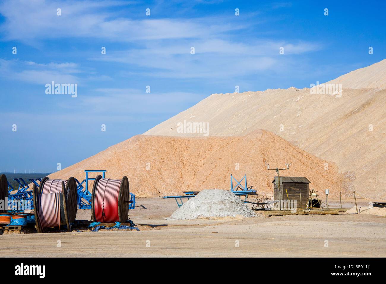 Paesaggio minerario di sale con grandi montagne saline e attrezzature industriali presso il sito di estrazione mineraria Foto Stock