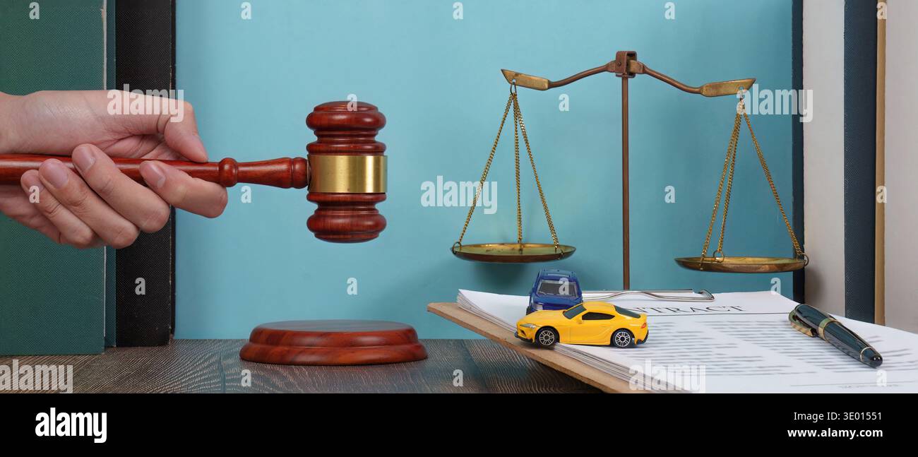 Contesto legale con bilance e automobili. Una scrivania da avvocato con martelletto e macchinine giocattolo. Foto Stock