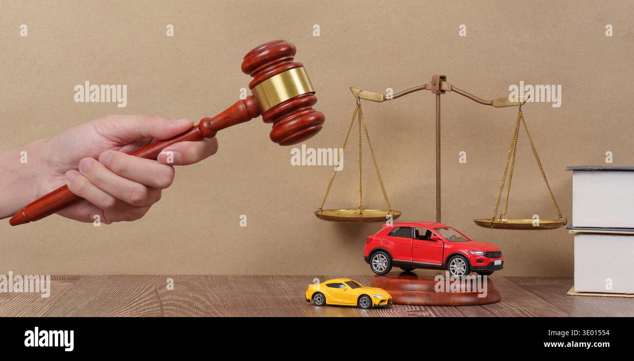 Contesto legale con bilance e automobili. Una scrivania da avvocato con martelletto e macchinine giocattolo. Foto Stock