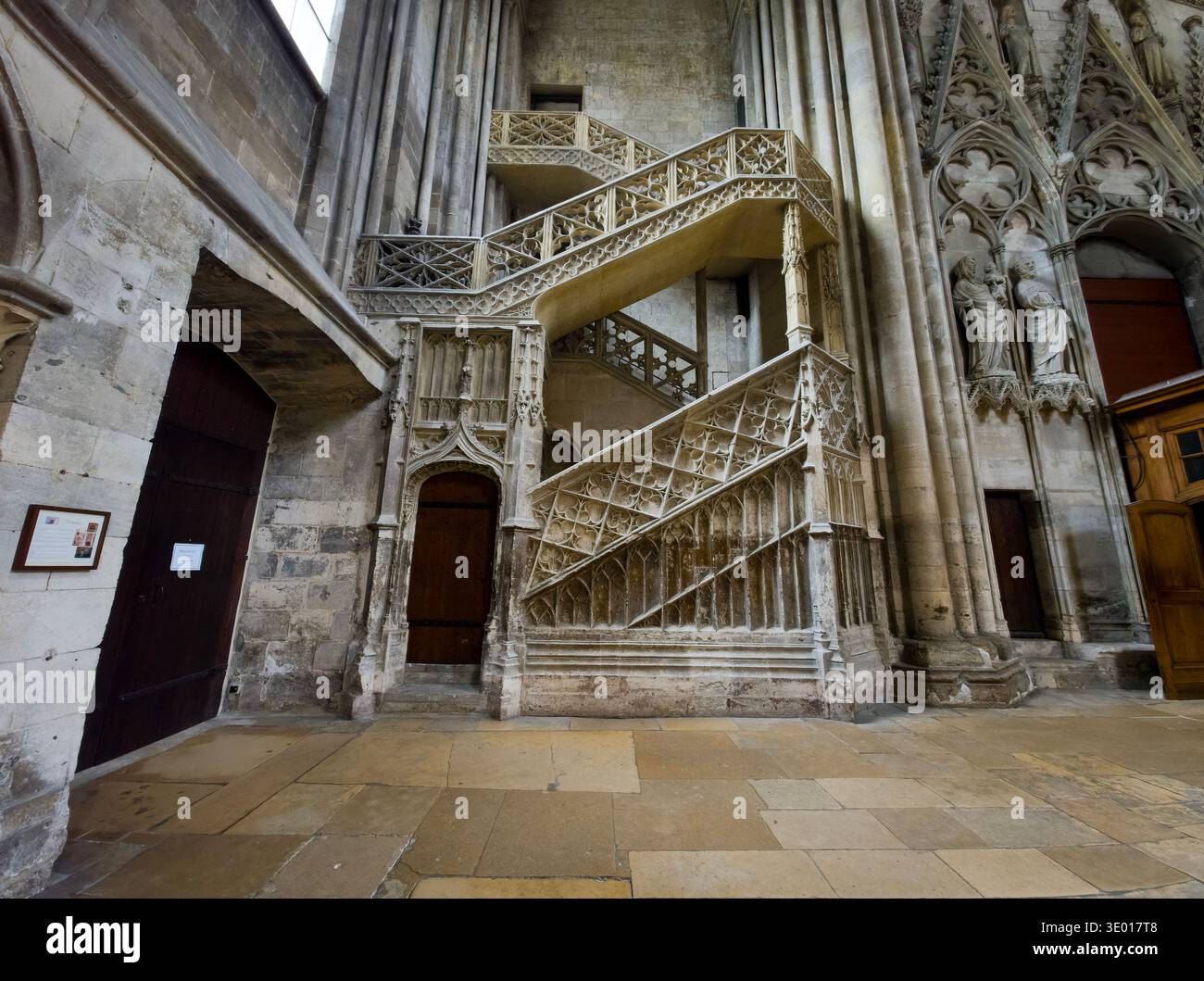 Intricata scalinata in pietra gotica fiammeggiante nella cattedrale di Rouen, caratterizzata da delicate incisioni all'aperto, trafori in pietra e archi ecclesiastici storici Foto Stock