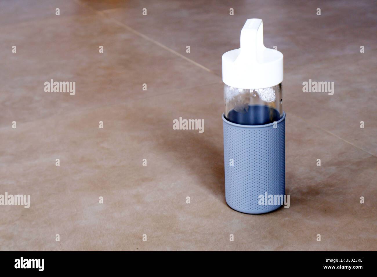 Bicchiere imbottigliato trasparente isolato sul pavimento del cemento, spazio di copia per testo. Concetto di stile di vita Foto Stock