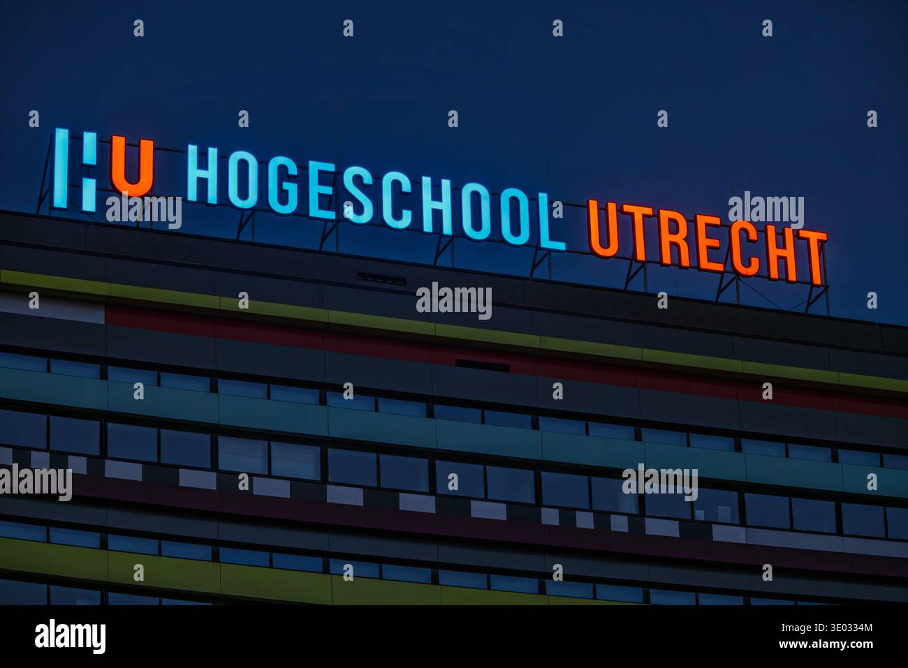 Insegna al neon illuminata dell'università HU Hogeschool Utrecht di scienze applicate in cima a un edificio moderno al crepuscolo o di notte. Utrecht, Paesi Bassi. 8 ma Foto Stock