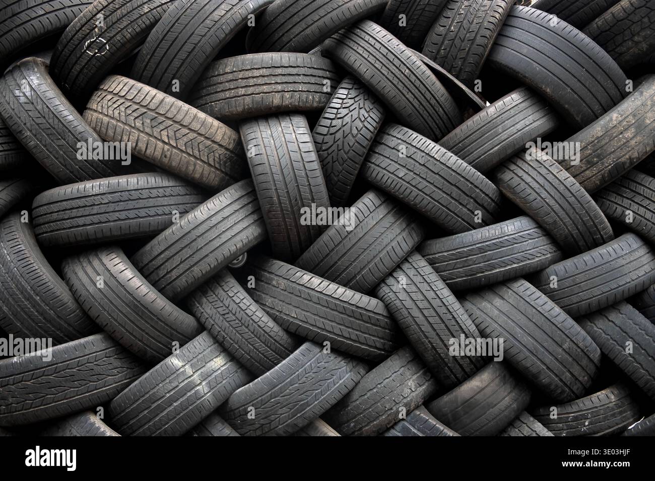 Una pila di pneumatici usati che creano uno schema geometrico. A Williamsburg, Brooklyn, New York. Probabilmente si dirige verso il riciclaggio. Foto Stock