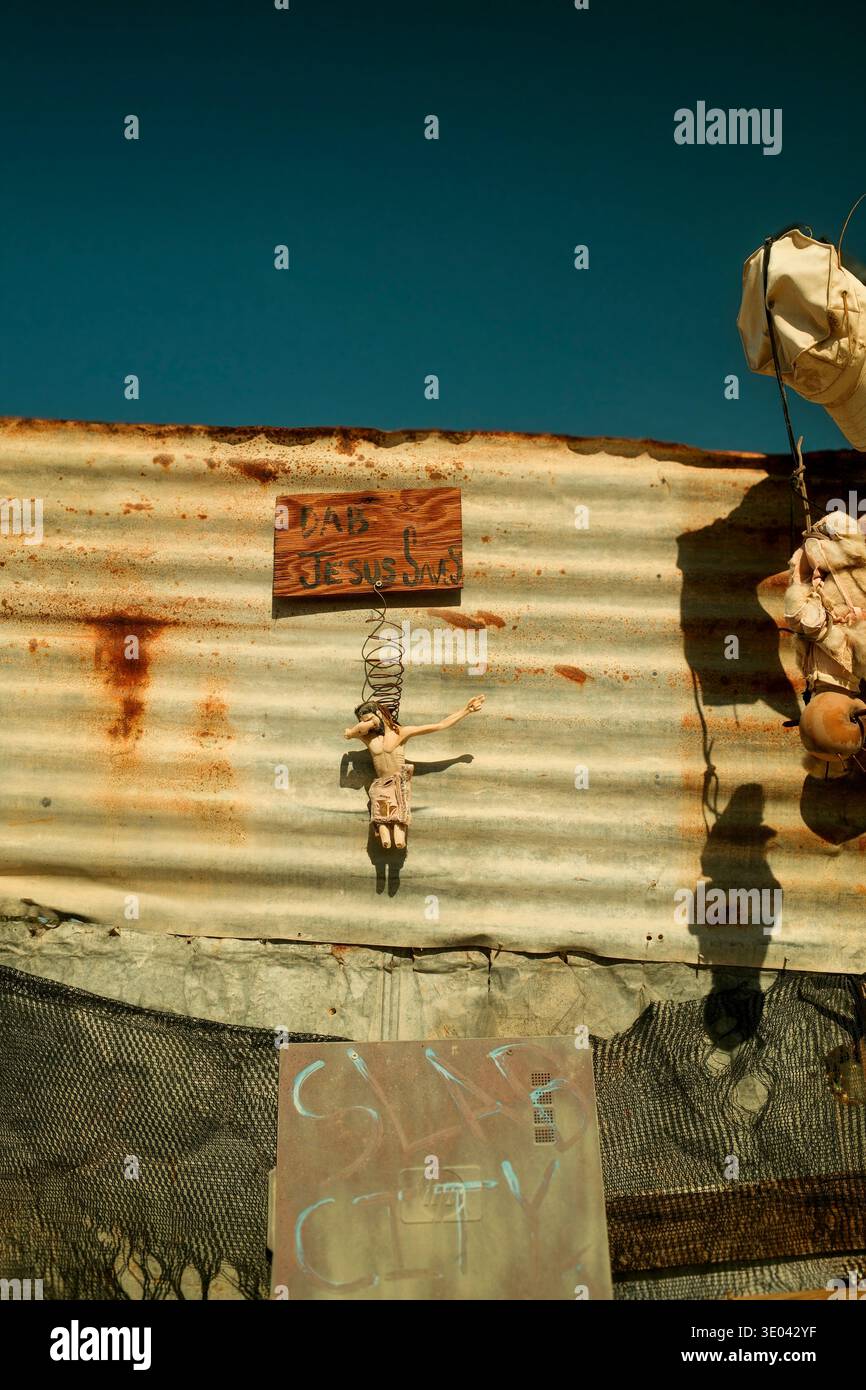 Recinzione e insegne fatte a mano nel paesaggio desertico di Slab City vicino al mare di Salton. Foto Stock
