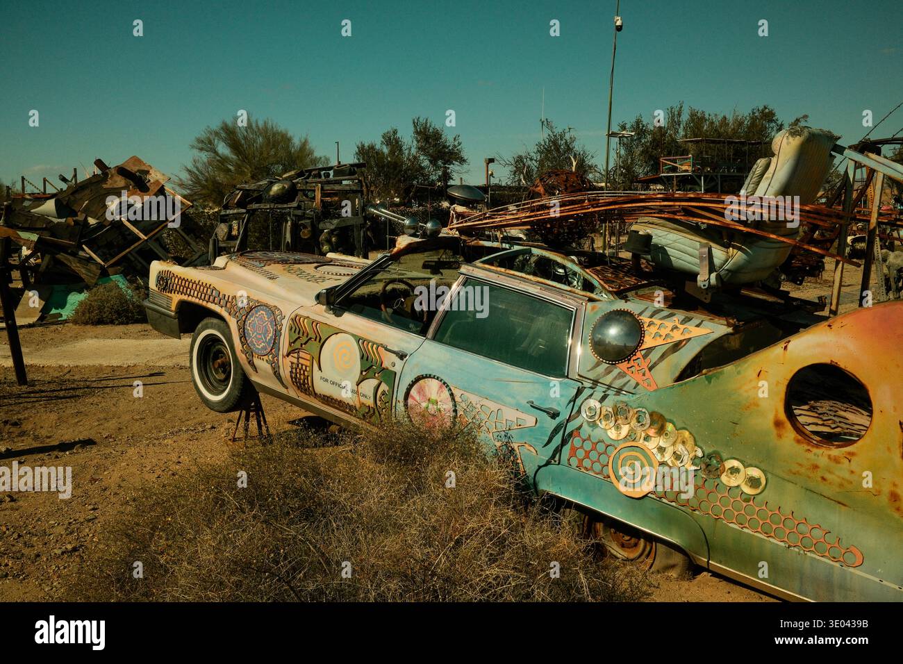 Auto d'arte dipinta circondata da sculture spazzatura del deserto a Slab City vicino al mare di Salton, California, Stati Uniti. Foto Stock