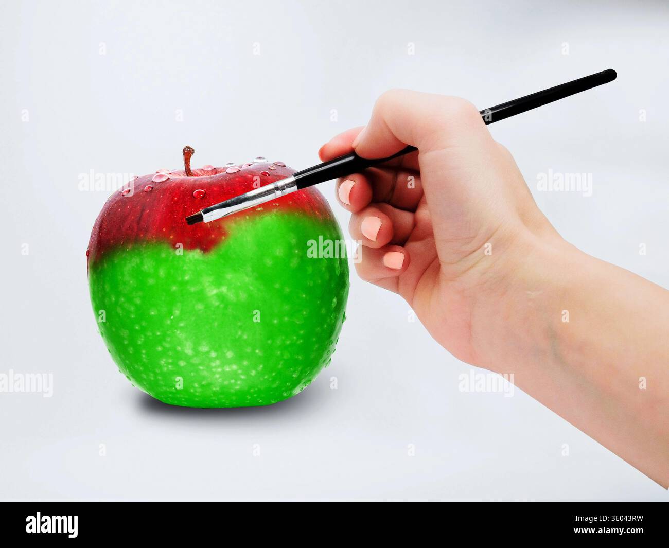 Pittura a mano Verde Mela Rosso con pennello cambiamento concettuale del colore e trasformazione creativa dell'arte alimentare Foto Stock