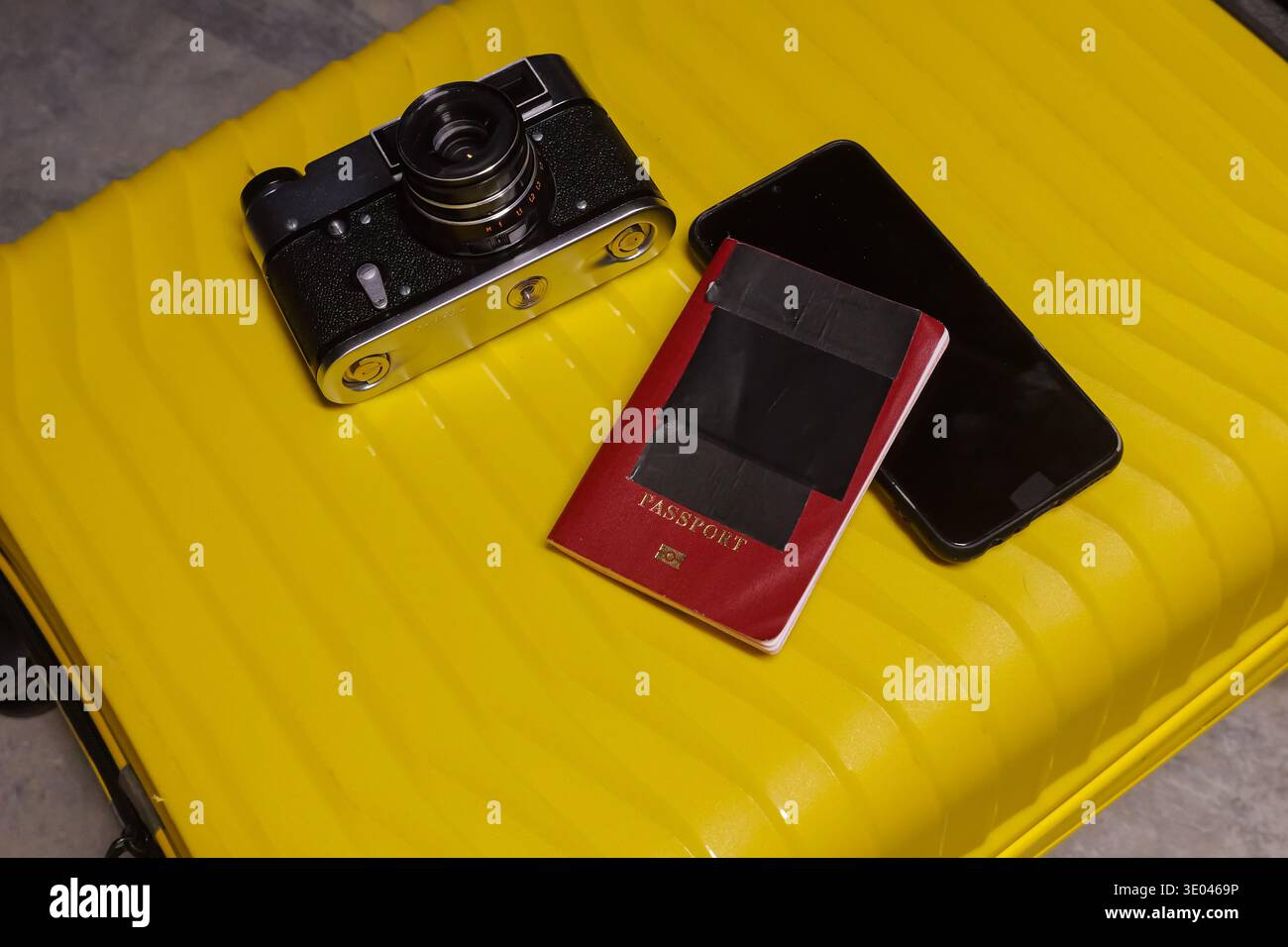 Fotocamera vintage e configurazione tecnica. Colorata collezione di dispositivi elettronici e accessori da viaggio. Disposizione di cimeli elettronici e bagagli Foto Stock