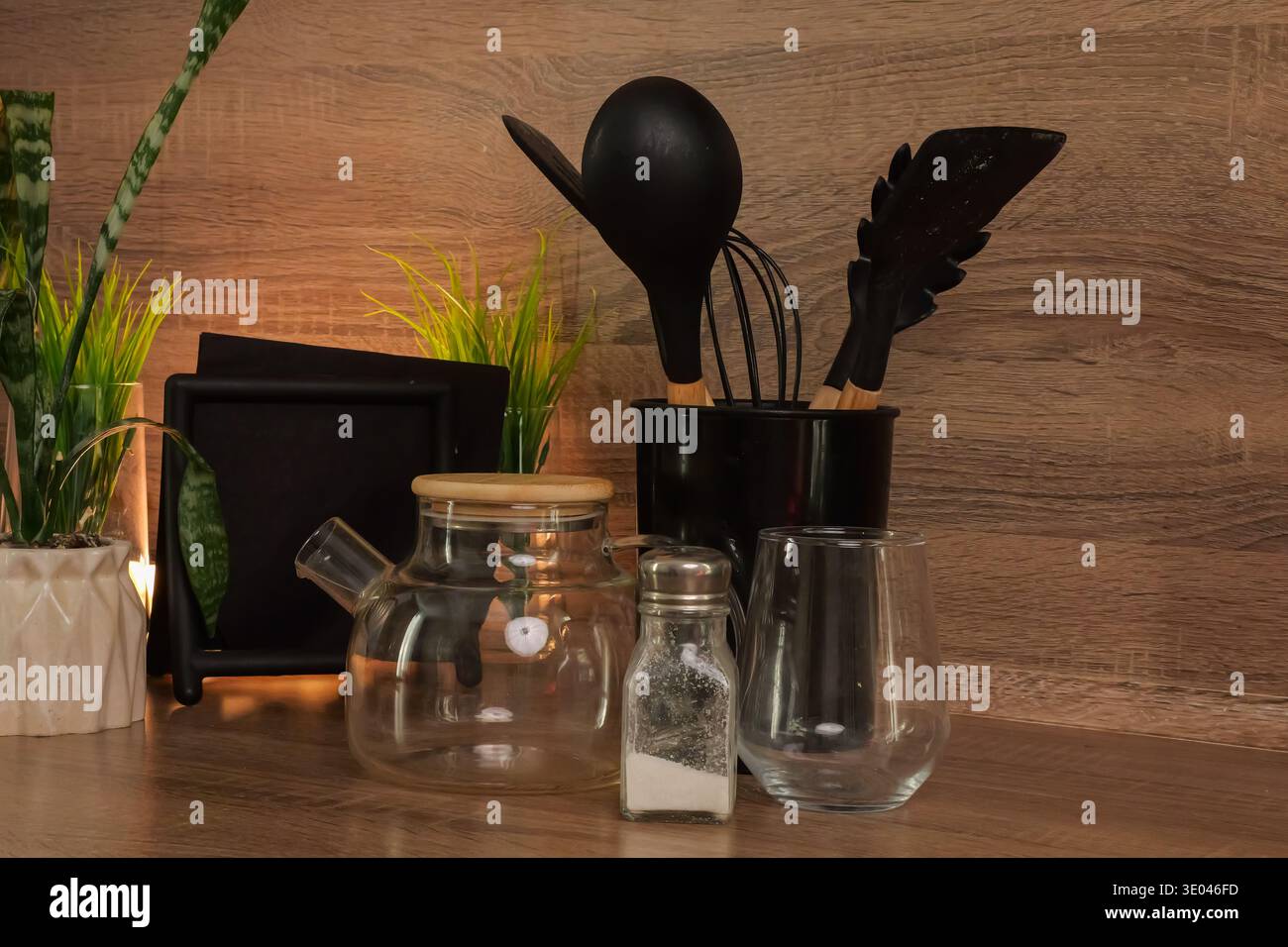 Utensili da cucina e arredi moderni. Eleganti utensili da cucina in vetro e legno per uno spazio di cottura ordinato. Accessori da cucina eleganti e funzionali disposti in modo ordinato Foto Stock