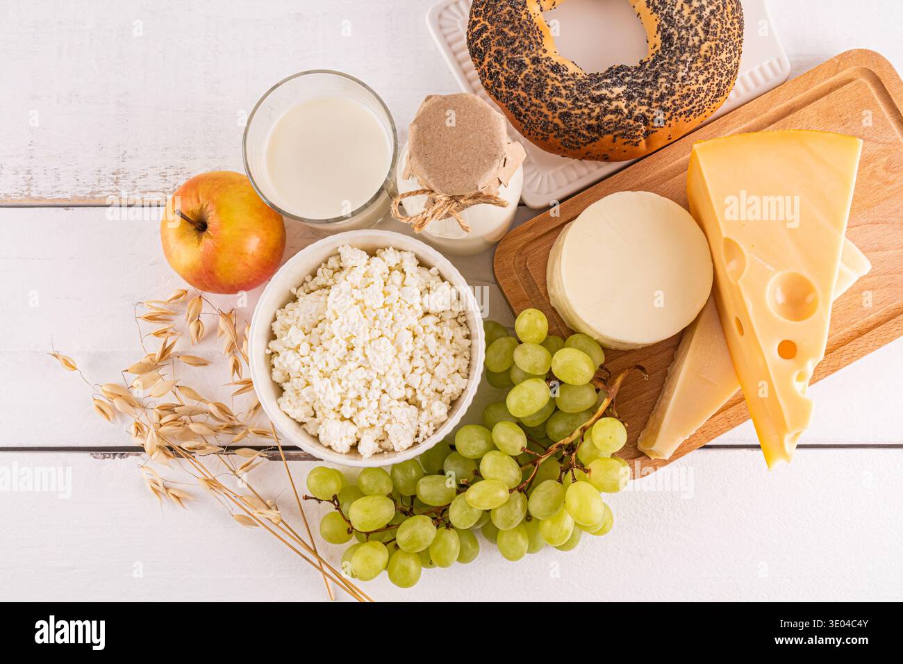 Una selezione splendidamente organizzata di cibi tradizionali Shavuot, con una varietà di prodotti lattiero-caseari, frutta fresca e cereali, a simboleggiare la taglia Foto Stock