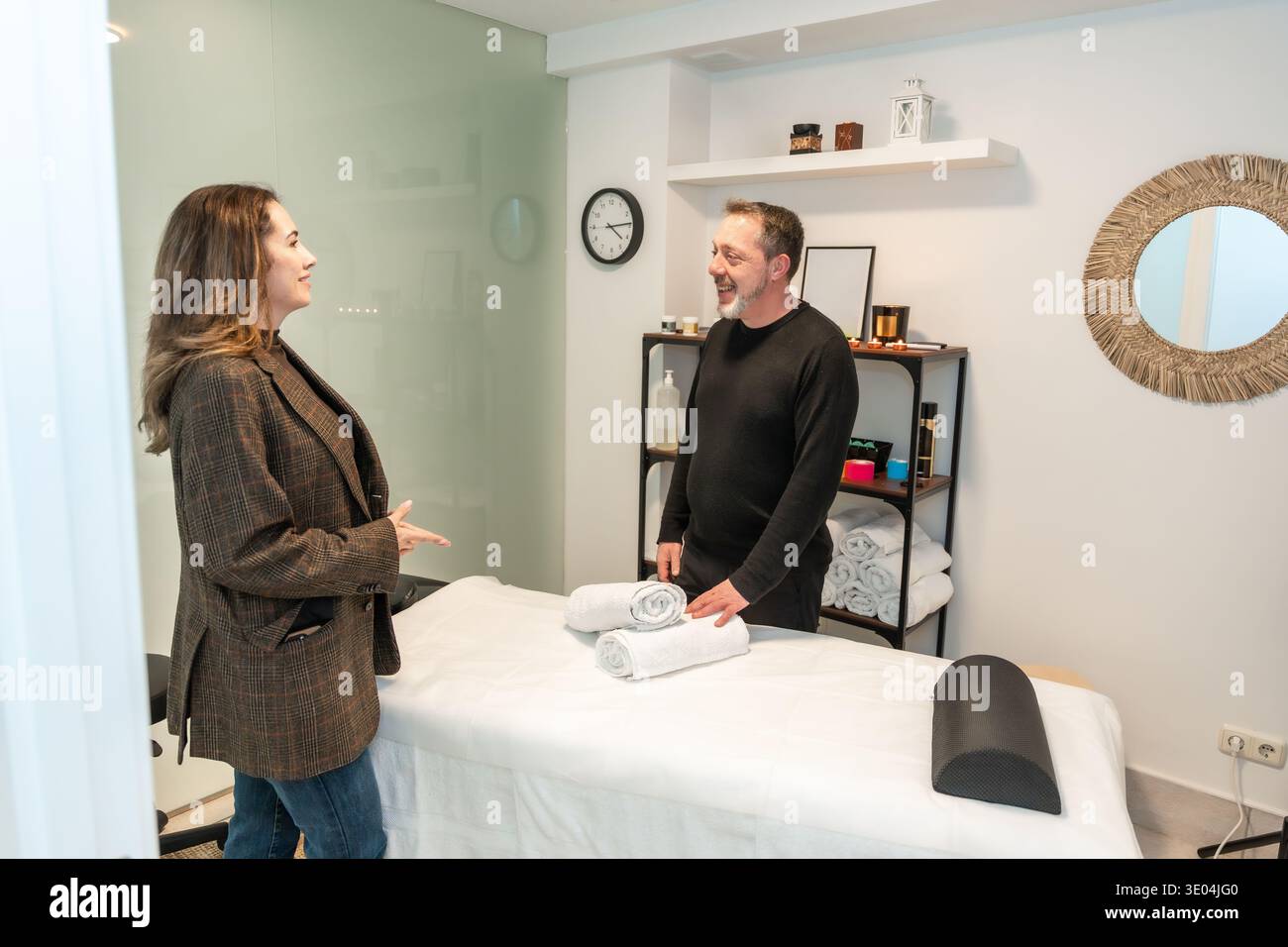 Cliente che parla con un massaggiatore professionista nel centro benessere Foto Stock