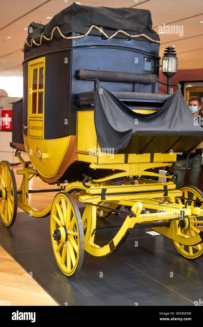 Una carrozza postale d'epoca meticolosamente conservata, esposta in un ambiente museale, caratterizzata da un caratteristico schema di colore giallo e nero... Foto Stock