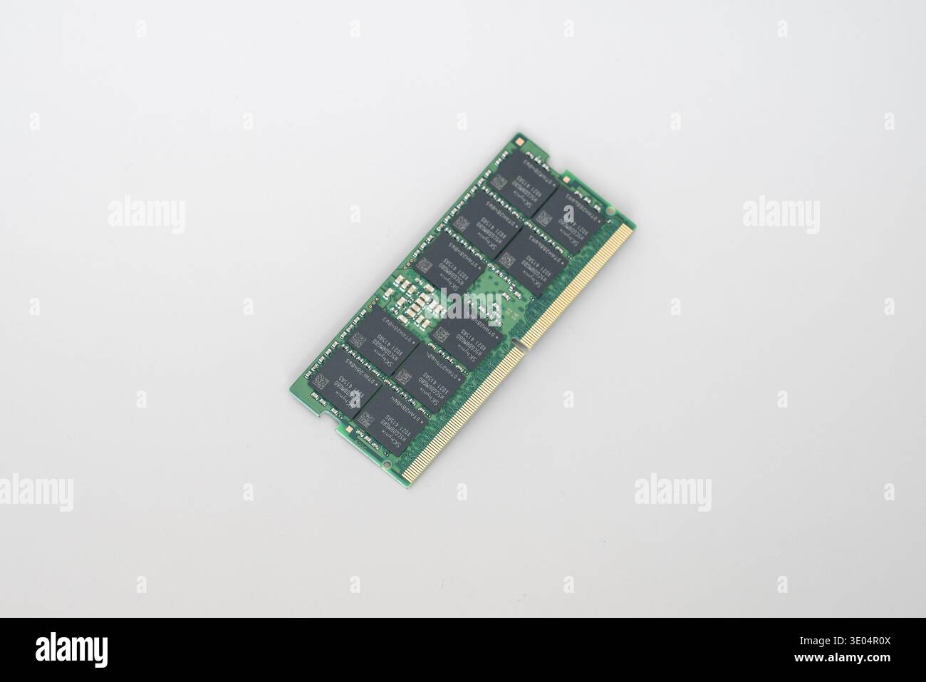 Primo piano di un modulo di memoria RAM DDR5 ECC verde con contatti dorati, con chip SK hynix, isolato su sfondo bianco. Foto Stock