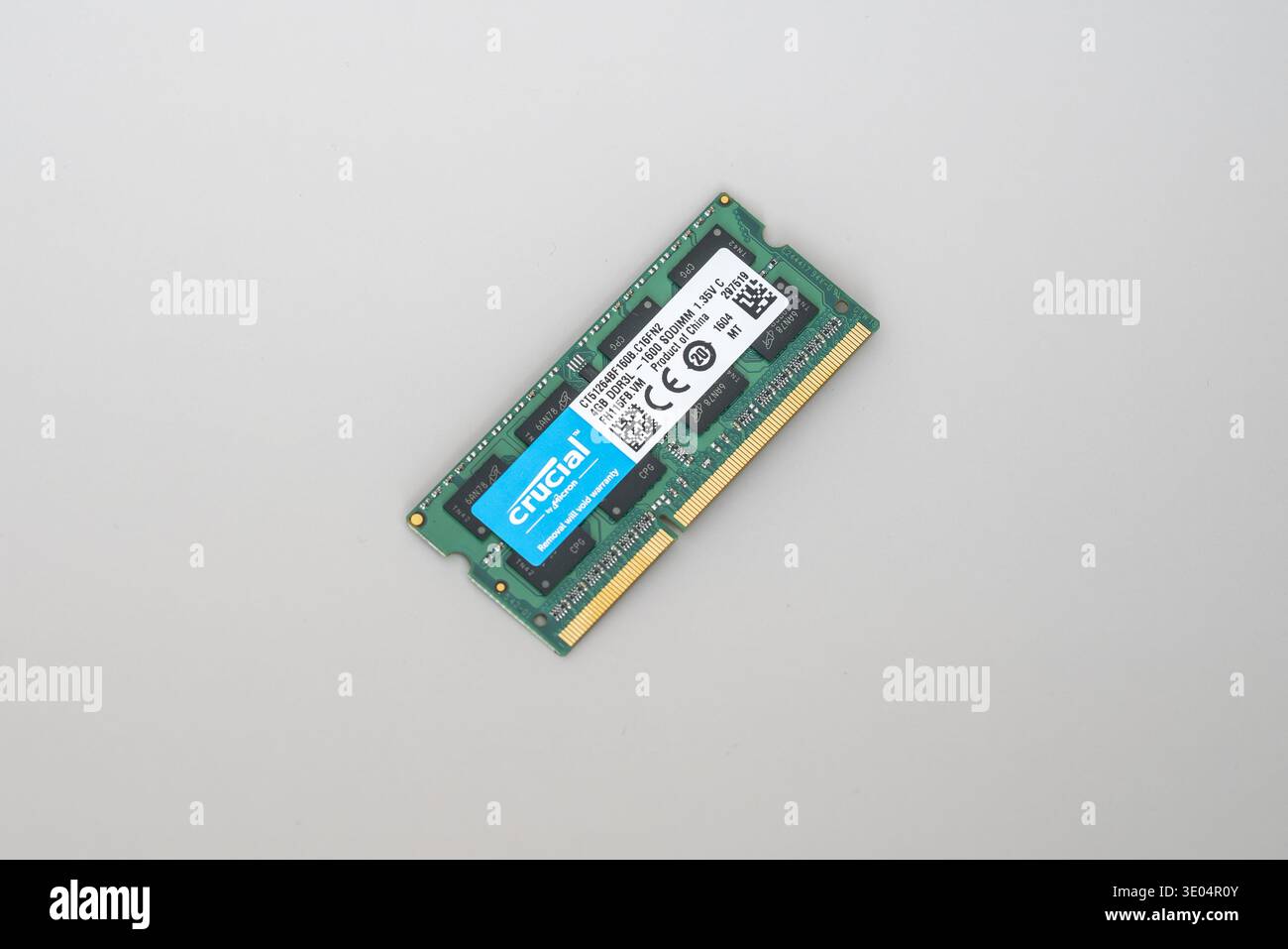 Primo piano di uno stick di memoria SODIMM DDR3 Crucial verde con etichetta blu, isolato su una superficie bianca semplice. Foto Stock