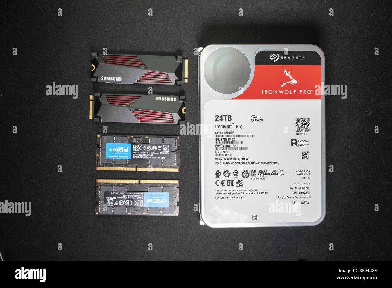 Dispositivi di storage ad alta capacità, tra cui disco fisso NAS da 24 TB, SSD Samsung NVMe, moduli RAM DDR5 Crucial organizzati per il concetto di crisi tecnologica e della memoria. Foto Stock