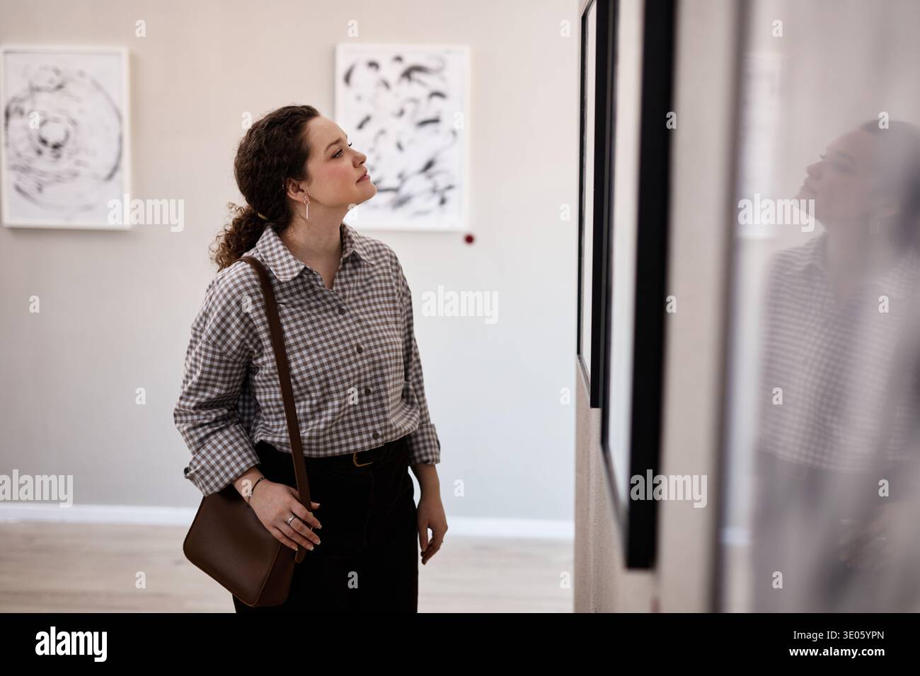 Giovane donna caucasica che osserva le opere d'arte nella Galleria d'Arte Contemporanea Foto Stock