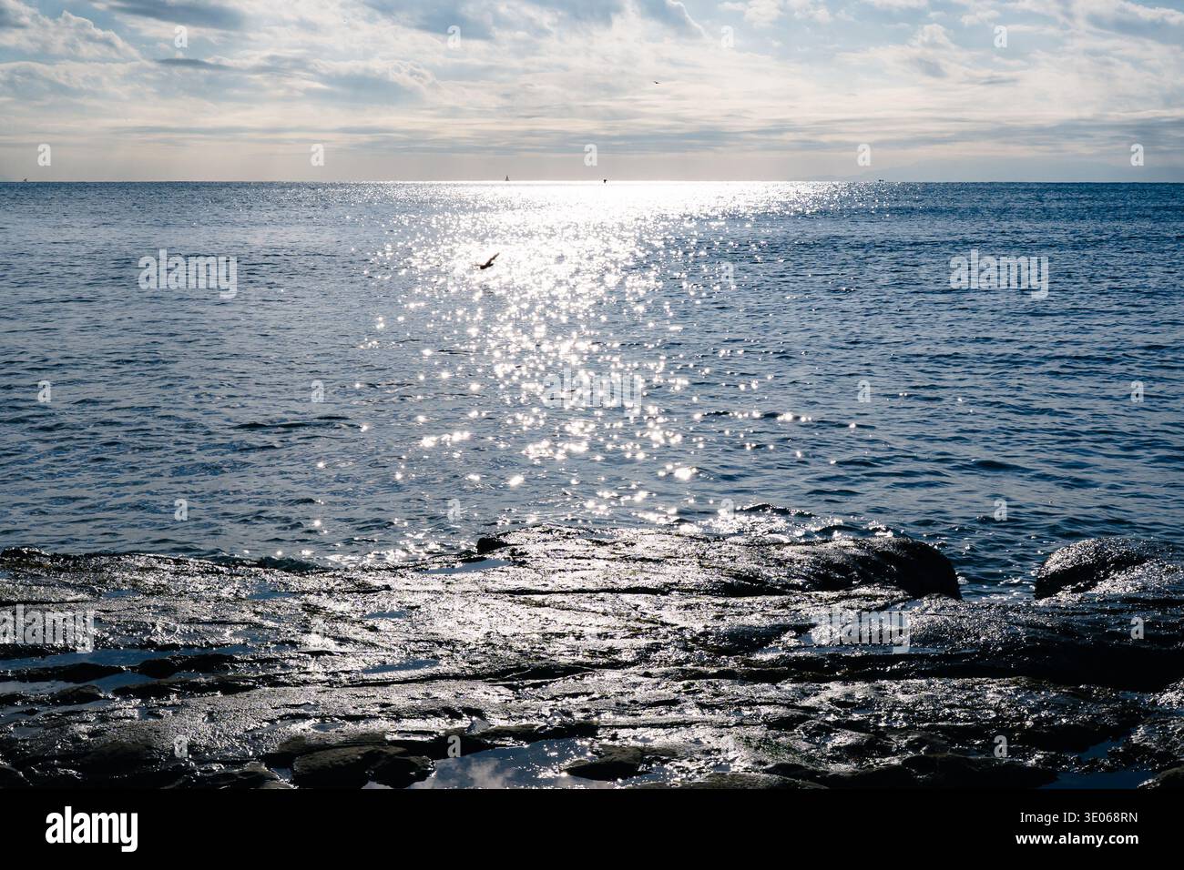 Formazione rocciosa costiera a Inamuragasaki con luce solare che si riflette sulla superficie del mare Foto Stock